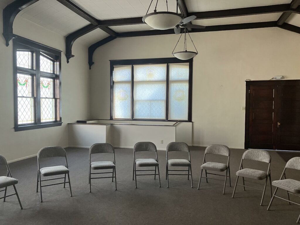 Main meeting room with folding chairs arranged in a circle